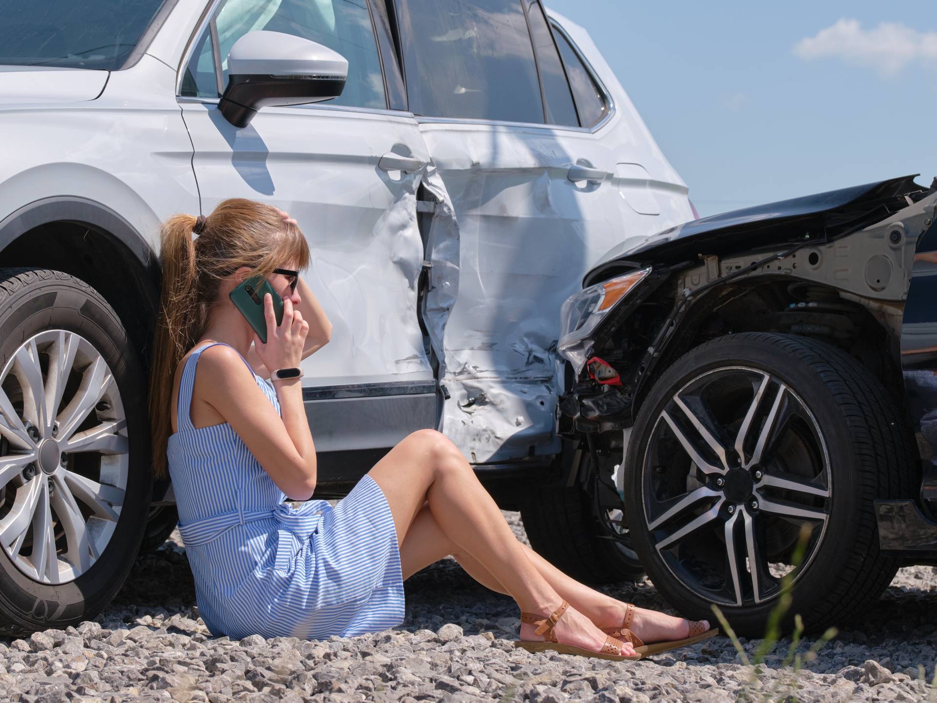 Stressed woman driver talking on mobile phone on street side calling for emergency service after car accident