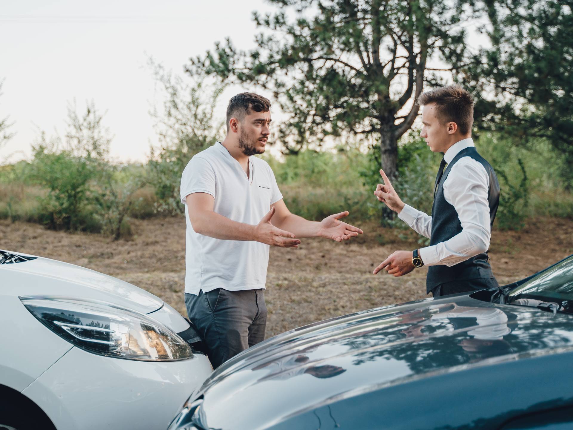 two Young Man Arguing With Each Other After Car Accident On Street At Outdoors