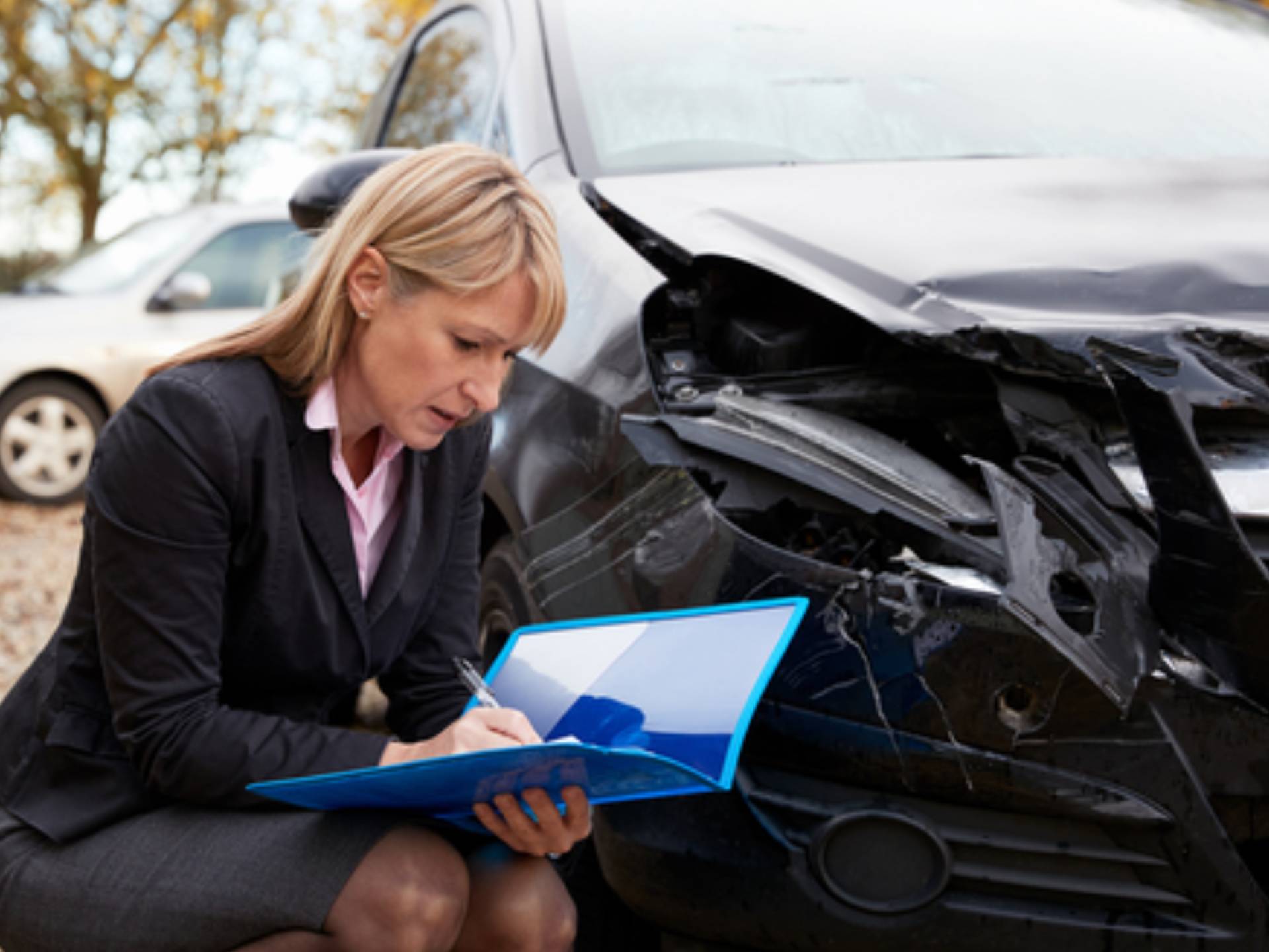 Female Loss Adjuster Writing Report On Damaged Car