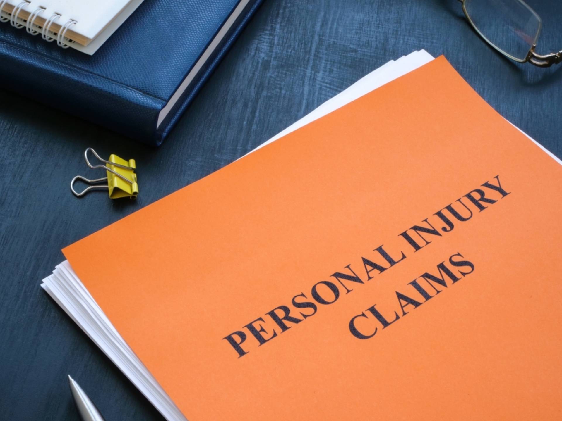 A stack of papers with personal injury claims on the table.