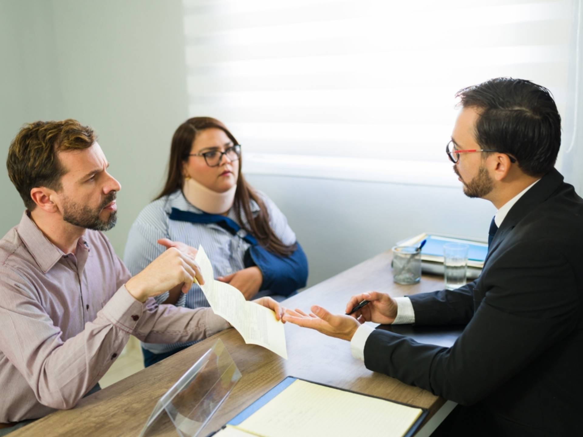 Man and injured woman discussing personal injury compensation with legal advisor